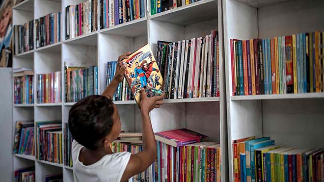 صبي يتصفح كتبًا في مكتبة لوا